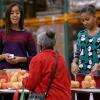 Barack Obama a distribué des colis de nourriture avec ses jolies filles Malia et Sasha, ainsi que son épouse Michelle, dans les locaux de l'association Capital Area Food Bank à Washington, le 27 novembre 2013.