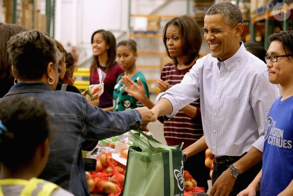 Barack Obama a distribué des colis de nourriture avec ses filles Malia et Sasha, ainsi que son épouse Michelle, dans les locaux de l'association Capital Area Food Bank à Washington, le 27 novembre 2013.