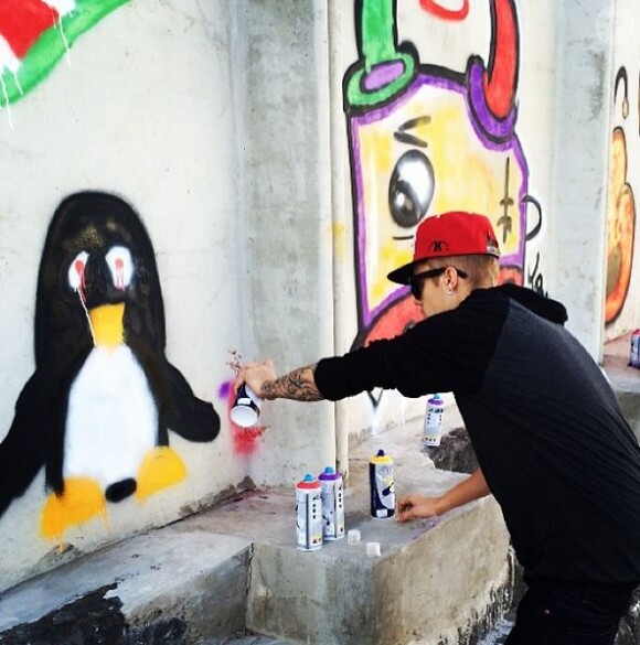 Justin Bieber se laisse prendre en photo alors qu'il fait des graffitis à Rio, au Brésil, novembre 2013.