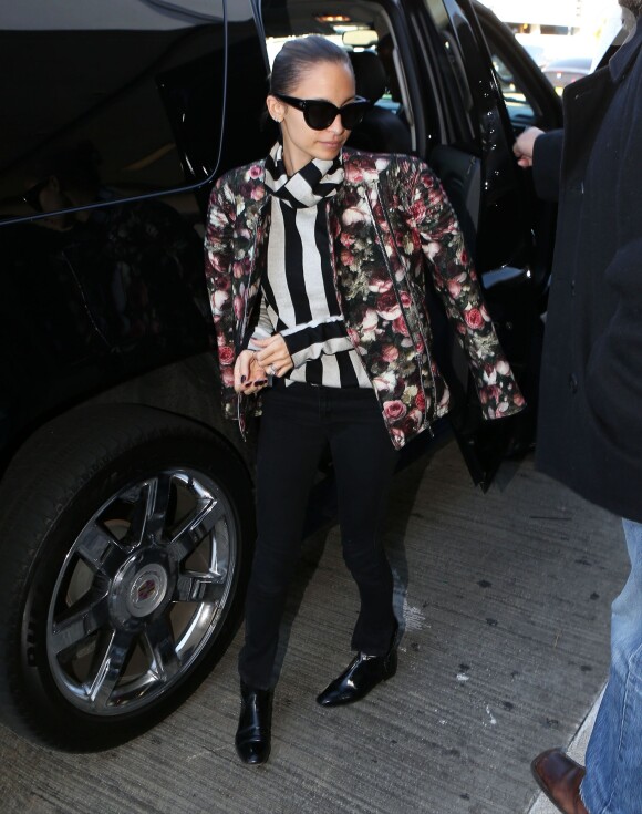 Nicole Richie arrive à l'aéroport de Los Angeles, habillée en noir et blanc avec des lunettes House of Harlow 1960 et une veste fleurie Givenchy (collection automne-hiver 2013). Le 4 décembre 2013.