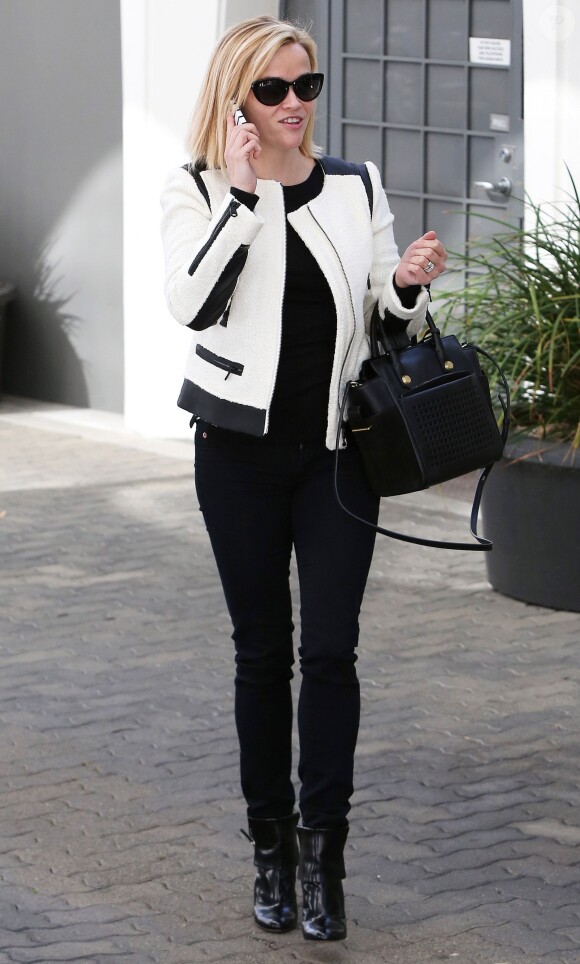 Reese Witherspoon, chic et souriante en noir et blanc, porte une veste Club Monaco (modèle Reid) et un sac Reed Krakoff (modèle Boxer en cuir perforé). Los Angeles, le 5 décembre 2013.