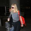 Gwyneth Paltrow traverse un terminal de l'aéroport de Los Angeles avec un sac rouge Balenciaga. L'actrice porte des bottines Stella McCartney (collection automne-hiver 2012). Le 3 décembre 2013.