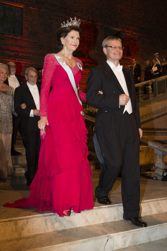 La reine Silvia de Suède au bras de Carl-Henrik Heldin, président du conseil de la Fondation Nobel, lors du banquet en l'honneur des Prix Nobel le 10 décembre 2013 à Stockholm