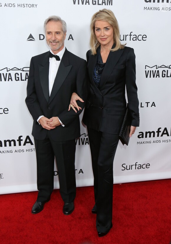 Sharon Stone, en charmante compagnie à son arrivée aux studios Milk pour le gala Inspiration de l'amFAR. Los Angeles, le 12 décembre 2013.