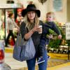 Hilary Duff, bras chargés avec un café, un jus vert, et son fils Luca, commence son shopping de Noël. Elle porte notamment un sac Goyard, un jean J Brand et des bottines Rag & Bone (modèle Kinsey). Beverly Hills, le 6 décembre 2013.