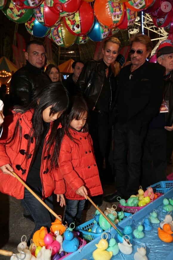 Johnny Hallyday, sa femme Laeticia et leurs filles Jade et Joy à la soirée d'inauguration de "Jours de Fêtes" au Grand Palais à Paris, le 19 décembre 2013. Les petites se sont amusées à la pêche aux canards.