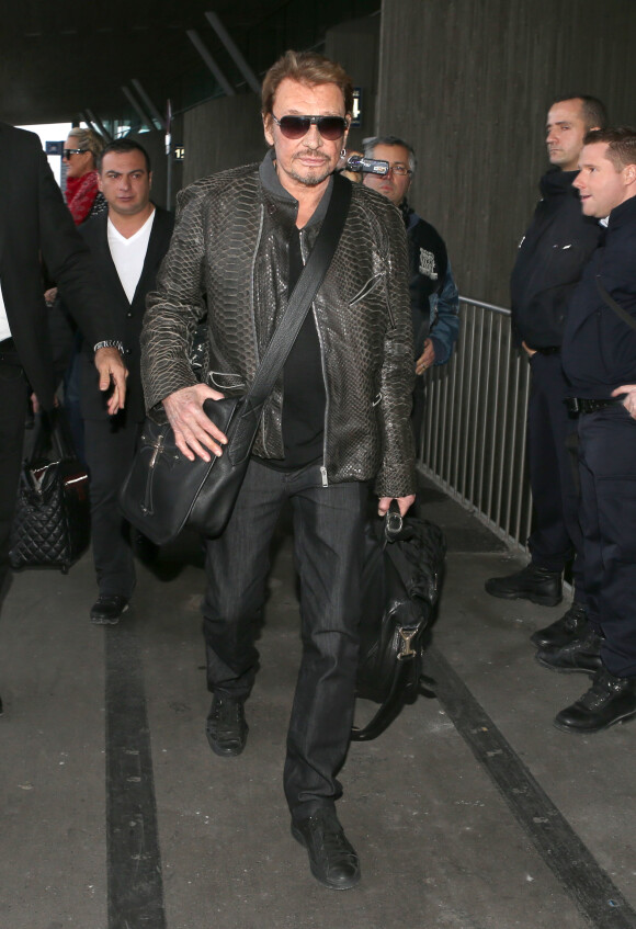 Johnny Hallyday à l'aéroport de Roissy-Charles de Gaulle pour prendre un avion direction Los Angeles, le 12 janvier 2014.