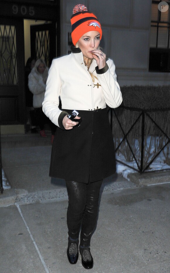 Kate Hudson à New York, porte un bonnet New Era à l'effigie de l'équipe des Broncos de Denver, un manteau bi-colore Fay, un pantalon J Brand et des souliers Jimmy Choo (modèle Bay). Le 29 janvier 2014.