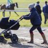 Zara Philips se promène avec son bébé Mia Tindall en poussette lors d'une course hippique à Barbury le 16 février 2014.
