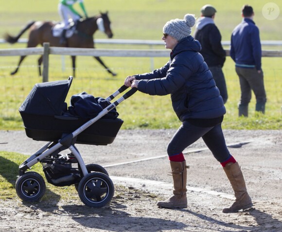 Zara Philips se promène avec son bébé Mia Tindall en poussette lors d'une course hippique à Barbury le 16 février 2014.