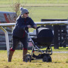 Zara Philips se promène avec sa fille Mia Tindall en poussette lors d'une course hippique à Barbury le 16 février 2014.