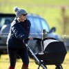 Zara Philips se promène avec sa fille Mia Tindall en poussette lors d'une course hippique à Barbury le 16 février 2014.