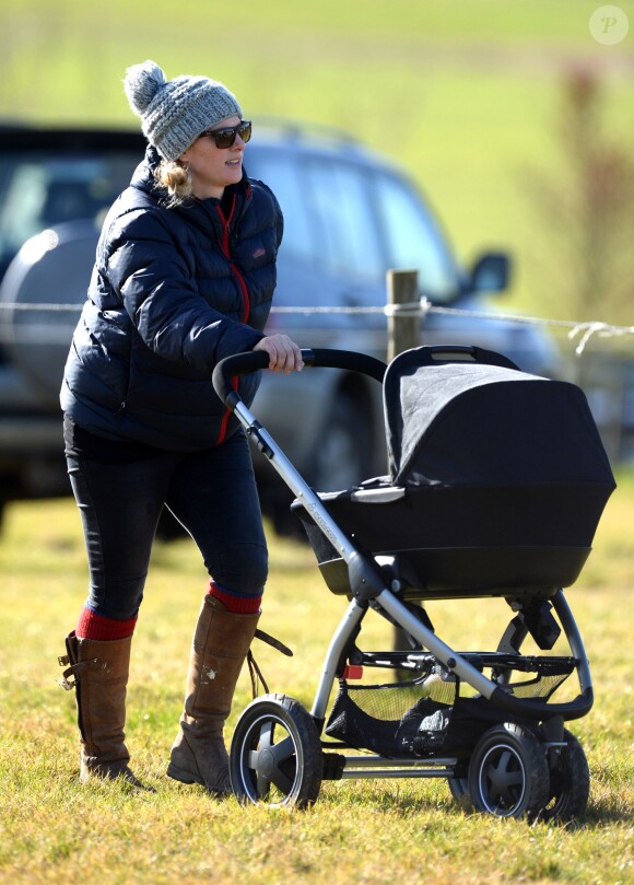 Zara Philips se promène avec sa fille Mia Tindall en poussette lors d'une course hippique à Barbury le 16 février 2014.
