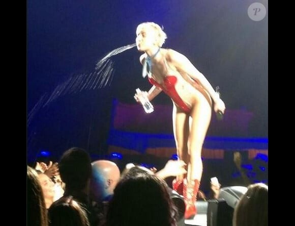 Miley Cyrus crache de l'eau sur ses fans lors de son concert à Milwaukee. Le 9 mars 2014.
