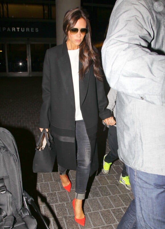 Victoria Beckham arrive à Los Angeles, habillée d'un manteau et d'un sac Victoria Beckham, d'un jean R13 et de souliers Manolo Blahnik. Le 28 mars 2014.