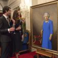 Kate Middleton discute avec Nick Cuthell devant le portrait d'Elizabeth II qu'il a réalisé, dévoilé le 10 avril 2014 lors d'une réception organisée par le gouverneur général de Nouvelle-Zélande à Wellington. 
