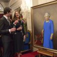  Kate Middleton discute avec Nick Cuthell devant le portrait d'Elizabeth II qu'il a réalisé, dévoilé le 10 avril 2014 lors d'une réception organisée par le gouverneur général de Nouvelle-Zélande à Wellington. 