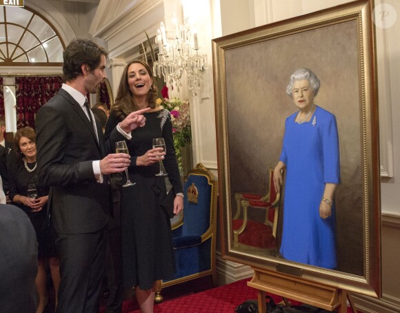 Kate Middleton discute avec Nick Cuthell devant le portrait d'Elizabeth II qu'il a réalisé, dévoilé le 10 avril 2014 lors d'une réception organisée par le gouverneur général de Nouvelle-Zélande à Wellington.
