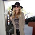 Rosie Huntington-Whiteley à l'aéroport de Los Angeles, porte un chapeau Eugenia Kim, un trench-coat et un t-shirt rayé, un sac Givenchy (modèle Pandora), un jean Frame Denim et des bottines Brian Atwood (modèle Cosmic). Le 16 avril 2014.