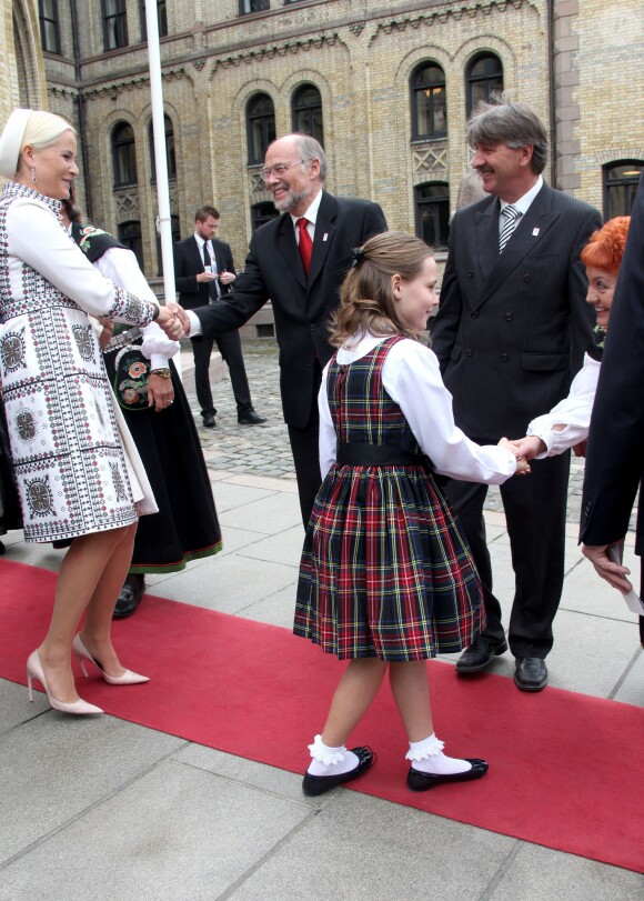 La princesse Ingrid Alexandra de Norvège, 10 ans, et sa mère la princesse Mette-Marit arrivant au Parlement. La jeune princesse faisait sa première visite officielle au Parlement (Storting) à Oslo le 15 mai 2014 à l'occasion de la cérémonie spéciale pour le bicentenaire de la Constitution norvégienne.