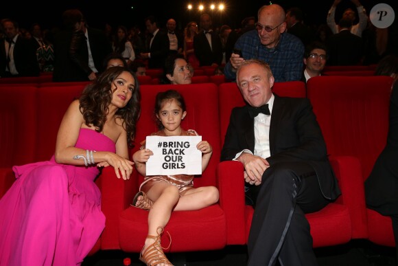 Salma Hayek, son mari François-Henri Pinault et leur fille Valentina Pinault (pancarte de soutien au lycéennes détenues au Nigéria) lors de l'hommage au cinéma d'animation et la présentations de "Kahlil Ghibran's The Prophet", lors du 67e Festival du film de Cannes le 17 mai 2014.