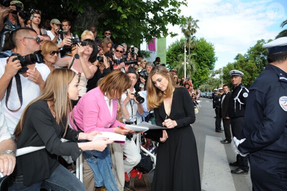 Julie Gayet signe des autographes lors de la montée des marches du 67e Festival du film de Cannes le 17 mai 2014.