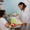 La princesse Stéphanie de Monaco, rose et layette à la main, a rencontré de jeunes mamans et leurs bébés au Centre hospitalier Princesse Grace, le 27 mai 2014, dans le cadre de la Fête des mères.