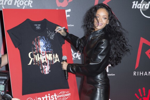Rihanna, signe le t-shirt à son effigie de la collection Artist Spotlight du Hard Rock Cafe, lors d'une conférence de presse dans l'établissement du 9e arrondissement. Paris, le 5 juin 2014.