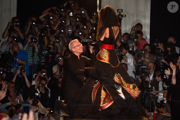 Jean Paul Gaultier, à genou face à Conchita Wurst qui assure le final de son défilé. Paris, le 9 juillet 2014.