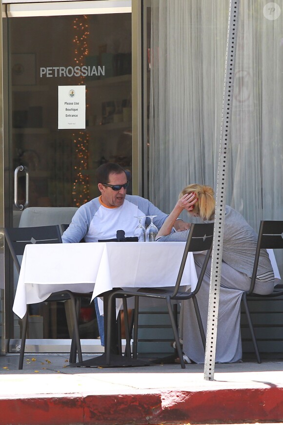 Melanie Griffith déjeune en terrasse du Petrossian avec un ami, Los Angeles, le 9 juillet 2014.