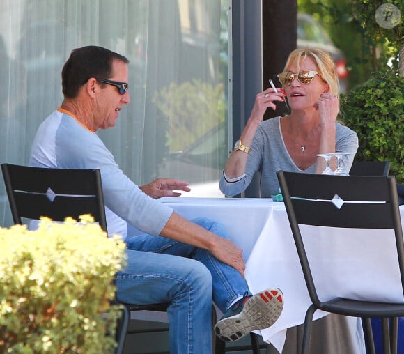 Melanie Griffith déjeune en terrasse du Petrossian avec un ami, Los Angeles, le 9 juillet 2014.