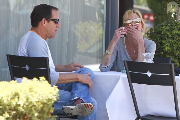 Melanie Griffith en terrasse du Petrossian avec un ami, Los Angeles, le 9 juillet 2014.
