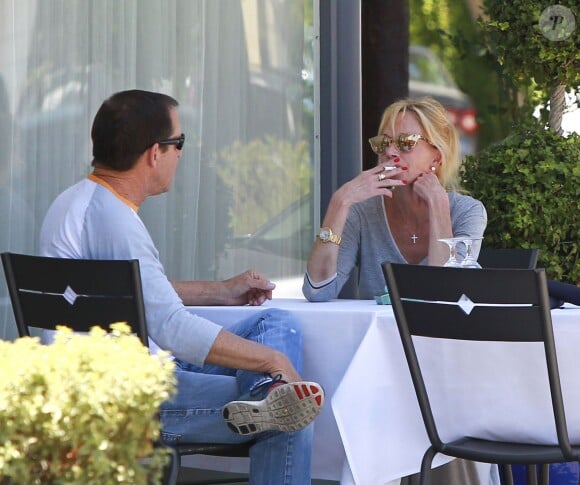 Melanie Griffith déjeune en terrasse du Petrossian avec un ami, Los Angeles, le 9 juillet 2014.