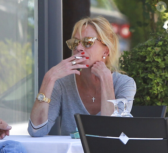 Melanie Griffith déjeune en terrasse du Petrossian avec un ami, Los Angeles, le 9 juillet 2014.