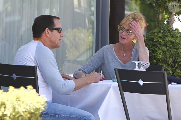 Melanie Griffith déjeune en terrasse du Petrossian avec un ami, Los Angeles, le 9 juillet 2014.