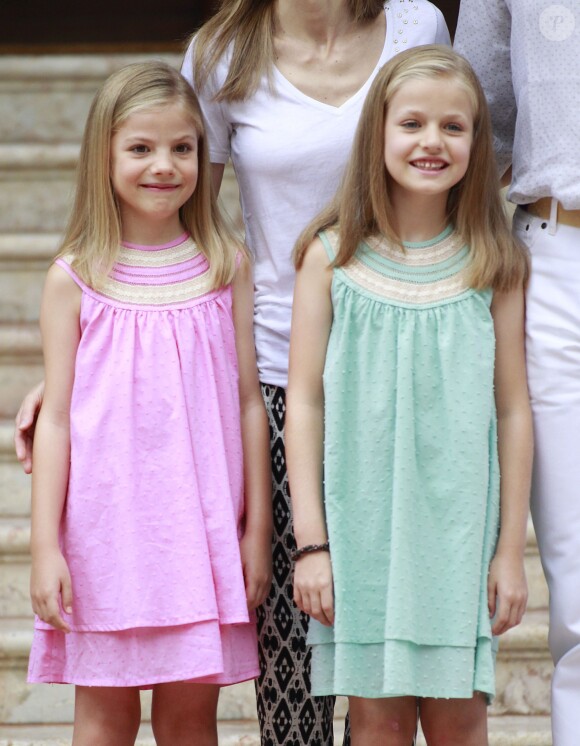 Sofia et Leonor, deux soeurs assorties... Le roi Felipe VI et la reine Letizia d'Espagne, avec leurs filles Sofia, en robe rose, et Leonor, princesse des Asturies, en robe bleue, ont posé pour la presse au palais de Marivent, le 5 août 2014 à Palma de Majorque, pour le début de leurs vacances d'été.