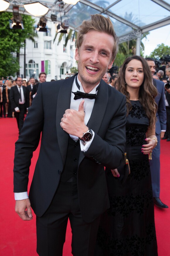 Philippe Lacheau (portant une montre Montblanc TimeWalker) et Alice David - Montée des marches du film "Dragon 2" lors du 67e Festival du film de Cannes le 16 mai 2014