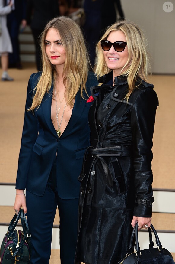 Cara Delevingne et Kate Moss arrivent, complices, au défilé de mode "Burberry Prorsum" à Londres. Le 15 septembre 2014 