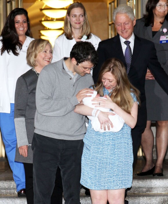 Chelsea Clinton prend la pose avec son mari Marc Mezvinsky, leur fille Charlotte et ses parents Bill et Hilary Clinton à la sortie de l'hôpital de New York, le 29 septembre 2014. 