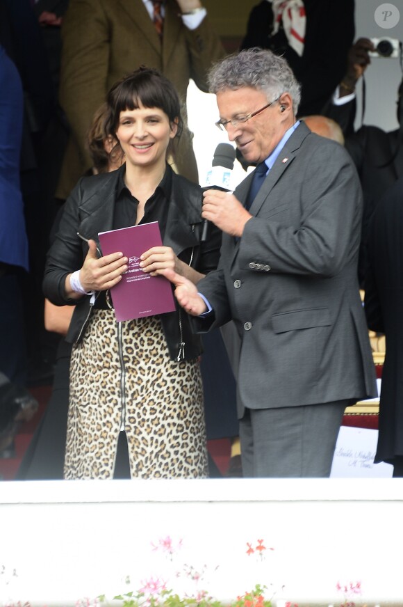 Juliette Binoche et Nelson Monfort lors du Qatar Prix de l'Arc de Triomphe à l'hippodrome de Longchamp à Paris, le 5 octobre 2014