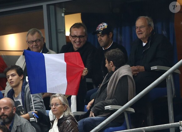 Marc Ladreit de Lacharrière, Jamel Debbouze et Patrick Bruel etson fils Léon brandissant fièrement le drapeau tricolore lors du match France-Portugal (2-1) au Stade de France à Saint-Denis, le 11 octobre 2014