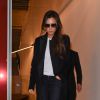 Victoria Beckham quitte sa boutique de vêtements à Londres, habillée d'un manteau Victoria Beckham et d'un t-shirt spécial Journée mondiale de lutte contre le sida, d'un jean noir R13 et de bottines Alaïa. Le 1er décembre 2014.