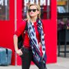 Reese Witherspoon à New York, porte des lunettes Ray-Ban, un sac à dos Proenza Schouler, un foulard Kenzo, un pull rouge Tory Burch, un pantalon Frame Denim (modèle Le Skinny) et des bottines Saint Laurent. Le 1er décembre 2014.