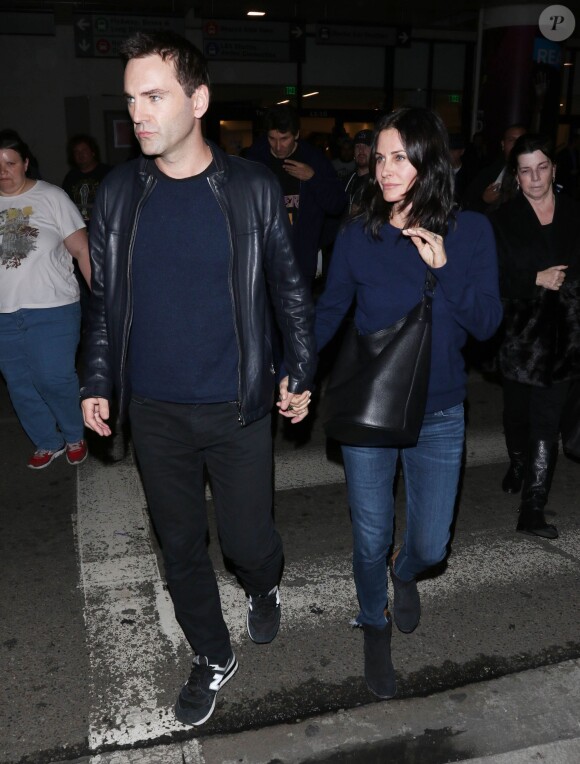 Courteney Cox et son fiancé Johnny McDaid à l'aéroport de Los Angeles, le 17 décembre 2014. Le couple semble heureux à leur retour d'un voyage romantique au cours duquel ils ont visité des caves au nord de la Californie.