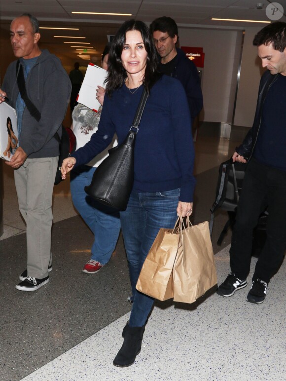 Courteney Cox et son fiancé Johnny McDaid à l'aéroport de Los Angeles, le 17 décembre 2014. Le couple semble heureux à leur retour d'un voyage romantique au cours duquel ils ont visité des caves au nord de la Californie.