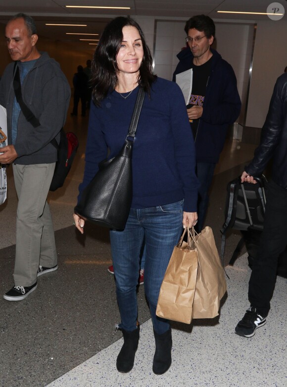 Courteney Cox et son fiancé Johnny McDaid à l'aéroport de Los Angeles, le 17 décembre 2014. Le couple semble heureux à leur retour d'un voyage romantique au cours duquel ils ont visité des caves au nord de la Californie.