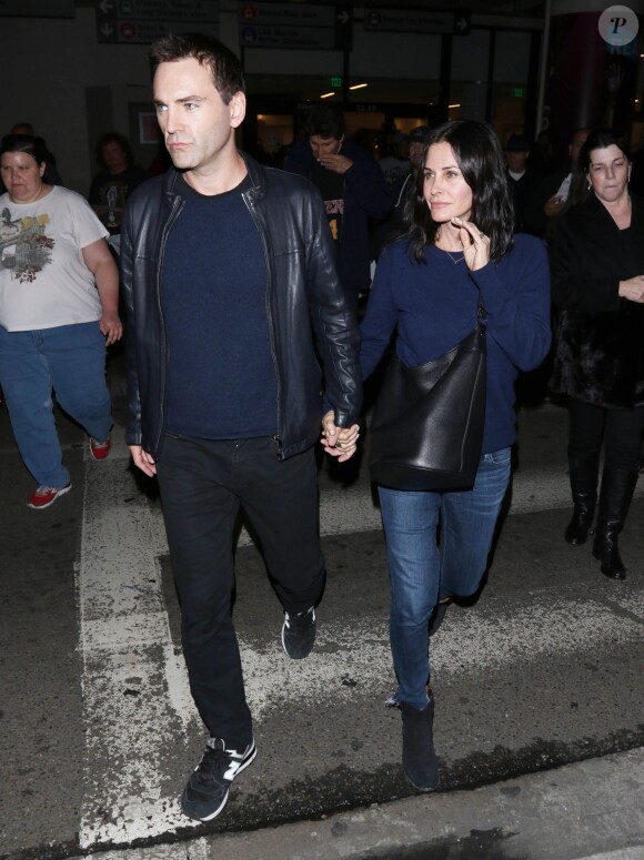 Courteney Cox et son fiancé Johnny McDaid à l'aéroport de Los Angeles, le 17 décembre 2014. Le couple semble heureux à leur retour d'un voyage romantique au cours duquel ils ont visité des caves au nord de la Californie.