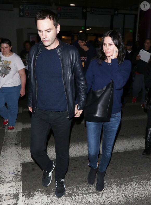 Courteney Cox et son fiancé Johnny McDaid à l'aéroport de Los Angeles, le 17 décembre 2014. Le couple semble heureux à leur retour d'un voyage romantique au cours duquel ils ont visité des caves au nord de la Californie.