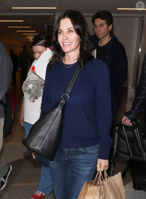 Courteney Cox et son fiancé Johnny McDaid à l'aéroport de Los Angeles, le 17 décembre 2014. Le couple semble heureux à leur retour d'un voyage romantique au cours duquel ils ont visité des caves au nord de la Californie.