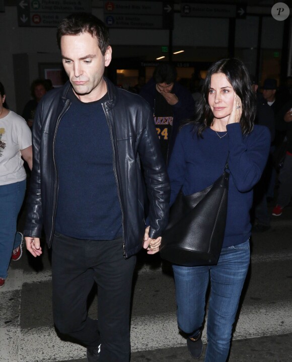 Courteney Cox et son fiancé Johnny McDaid à l'aéroport de Los Angeles, le 17 décembre 2014. Le couple semble heureux à leur retour d'un voyage romantique au cours duquel ils ont visité des caves au nord de la Californie.